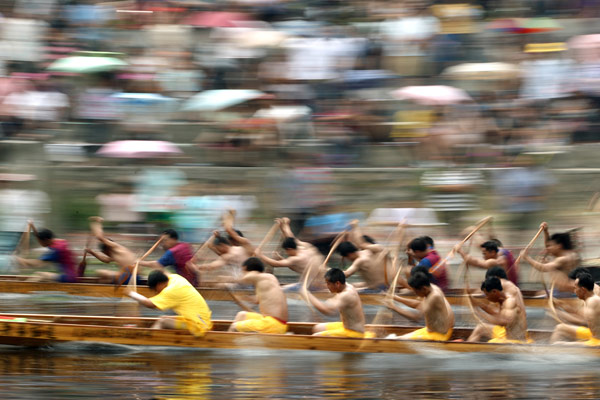 Participants row their boats during a race on a river in Jinli township, Gaoyao city, in South China&apos;s Guangdong province, June 2, 2011. [Xinhua] 