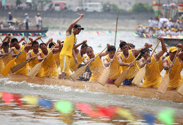 Participants row their boats during a race on a river at the border of Guangzhou and Foshan in South China&apos;s Guangdong province, June 2, 2011. [Xinhua] 