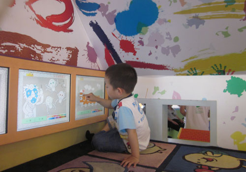 A tot plays with a digital painting exhibit at the Magic Bean House in Beijing. [Photo:CRIENGLISH.com]