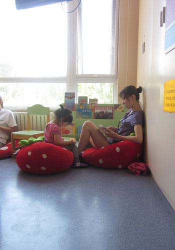 A young girl and her mother have a quiet reading break as they sit on plush strawberries at the Magic Bean House. [Photo:CRIENGLISH.com] 