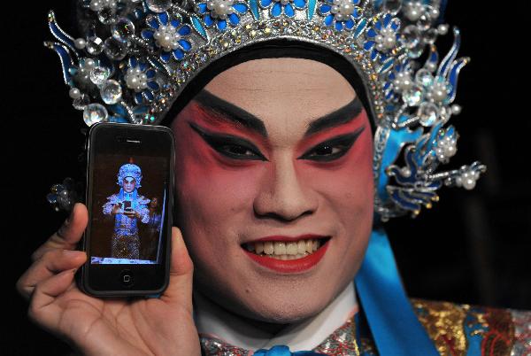 An opera player shows a photo of himself after make-up in south China's Hong Kong, June 2, 2011. Chinese Opera Festival will be held here from June 3 and nine opera troupes will perform traditional Chinese operas during the festival.