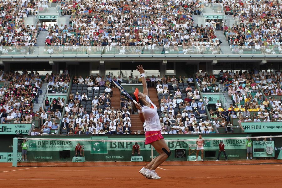 Li Na of China serves to Francesca Schiavone of Italy during their women's final in the French Open tennis championship at the Roland Garros stadium in Paris, June 4, 2011. [163.com]