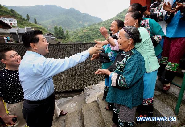 Jia Qinglin (2nd L), a member of the Standing Committee of the Political Bureau of the Communist Party of China (CPC) Central Committee, who is also chairman of the Chinese People's Political Consultative Conference (CPPCC) National Committee, visits residents of ethnic minorities in Maoping Village, Morong Town of Guzhang County in central China's Hunan Province, June 2, 2011. Jia paid an inspection visit in Guizhou Province, Chongqing Municipality and Hunan from May 31 to June 4. [Yao Dawei/Xinhua]