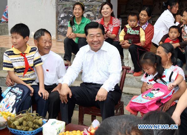 Jia Qinglin (C), a member of the Standing Committee of the Political Bureau of the Communist Party of China (CPC) Central Committee, who is also chairman of the Chinese People's Political Consultative Conference (CPPCC) National Committee, chats with villagers in Shuangfeng Village, Suoxiyu Tujia Town of Zhangjiajie in central China's Hunan Province, June 3, 2011. Jia paid an inspection visit in Guizhou Province, Chongqing Municipality and Hunan from May 31 to June 4. [Yao Dawei/Xinhua]