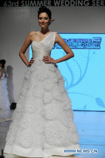 A model presents a wedding dress by designer Dorian Ho during the Second Asian Wedding and Design Competition in Hong Kong, south China, June 4, 2011. Final result of the fashion contest will be released on Aug. 27, 2011, organizers announced in a press conference Saturday together with a shortlist of 30 contestants. [Song Zhenping/Xinhua]