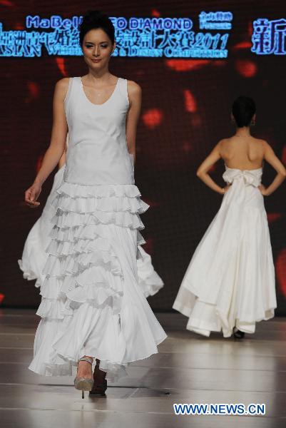 A model presents a wedding dress by designer LuLu Cheung during the Second Asian Wedding and Design Competition in Hong Kong, south China, June 4, 2011. Final result of the fashion contest will be released on Aug. 27, 2011, organizers announced in a press conference Saturday together with a shortlist of 30 contestants. [Song Zhenping/Xinhua]