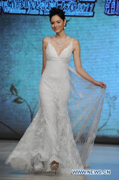 A model presents a wedding dress by designer Arthur Lam during the Second Asian Wedding and Design Competition in Hong Kong, south China, June 4, 2011. Final result of the fashion contest will be released on Aug. 27, 2011, organizers announced in a press conference Saturday together with a shortlist of 30 contestants. [Song Zhenping/Xinhua]