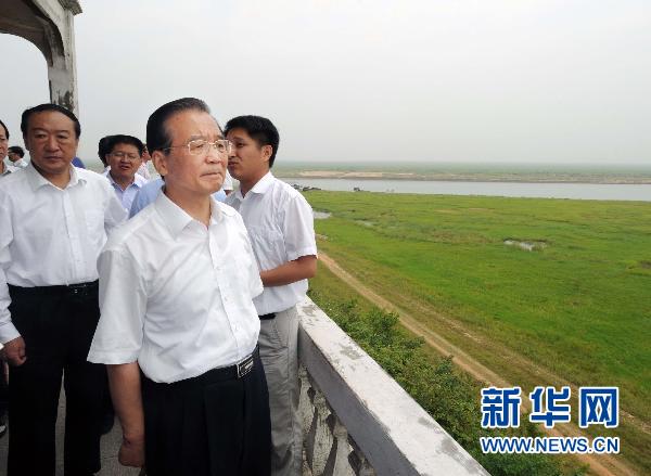 Chinese Premier Wen Jiabao looks at lake-turned grassland as the result of lingering drought in Yongxiu county of East China's Jiangxi province June 5, 2011. [Photo/Xinhua]