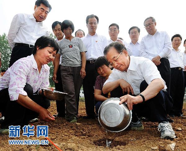 Chinese Premier Wen Jiabao waters a drought-plagued corn crop in Xiangfan city of Central China's Hubei province June 4, 2011. [Photo/Xinhua]