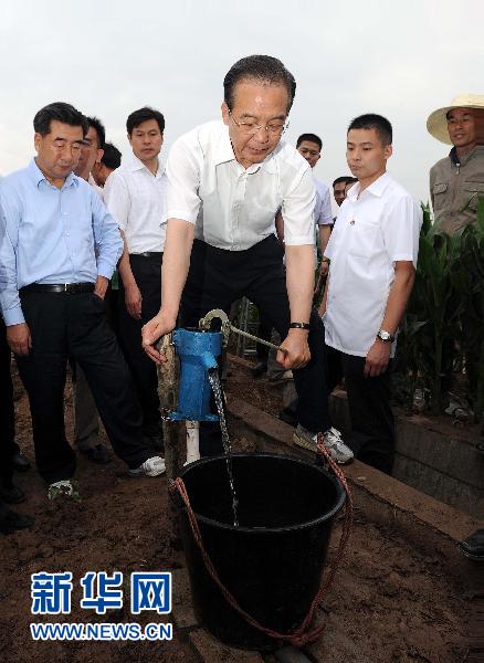 Chinese Premier Wen Jiabao (front) pumps water to irrigate a cotton field in Xinzhou Village, Liulinzhou Town of Yueyang City in central China's Hunan Province, June 2, 2011. Wen made an inspection tour in the drought-striken provinces of Jiangxi, Hunan and Hubei from June 2 to 4.