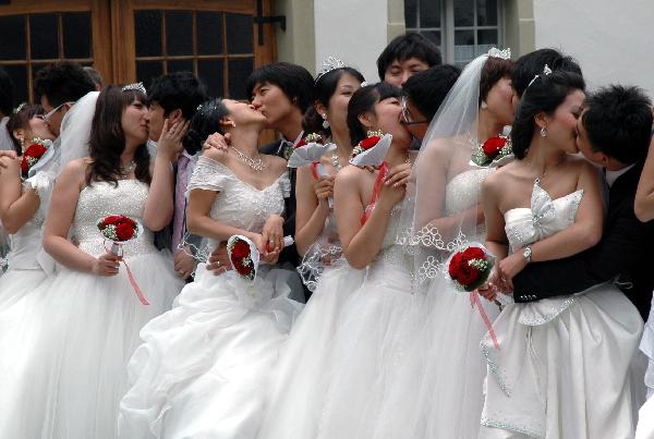 Chinese bridal couples kiss during their collective wedding at New Swan Stone Castle in Fuessen, south German, on June 3, 2011. A total of 31 couples from north China's Tianjin Municipality held a collective wedding on Friday at New Swan Stone Castle, one of the most popular travel destinations in Europe. [Xinhua/Wu Mei] 