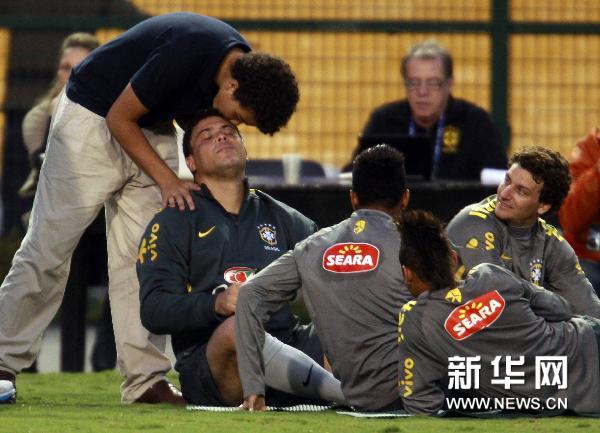 Brazilian soccer player Ronaldo (2nd L) is kissed by his son Ronald (L) after a training session in Sao Paulo June 6, 2011. Brazil will face Romania on Tuesday in Sao Paulo in a friendly soccer match that also will be the official farewell game for the former World Player of the Year Ronaldo. (Xinhua/Reuters Photo) 