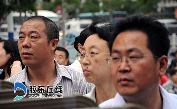 Parents wait for their children in an examination site in a high school in Yangtai, Shandong Province on July 7, 2011. About 9.33 million students have registered to take the annual national college entrance exams, or gaokao, on June 7 and 8 this year.