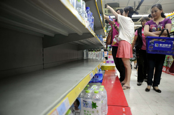 Residents in Hangzhou, capital of Zhejiang province, rush to buy bottled water at supermarkets on Monday. The demand for bottled water rose quickly after a chemical spill polluted a river from which the province draws drinking water. [China Daily] 