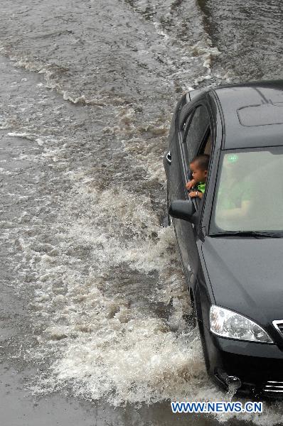 A car runs on the flooded street in Hangzhou, capital of east China&apos;s Zhejiang Province, June 6, 2011. Continued rainfall hit Hangzhou in recent days, disturbing the city&apos;s traffic. Multiple places in Zhejiang have been suffering from drought since spring of this year. [Xinhua] 