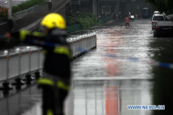 A firefighter works on the flooded street in Hangzhou, capital of east China&apos;s Zhejiang Province, June 6, 2011. Continued rainfall hit Hangzhou in recent days, disturbing the city&apos;s traffic. Multiple places in Zhejiang have been suffering from drought since spring of this year. [Xinhua] 