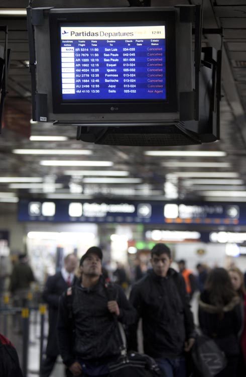 Passengers check the flight information at the Jorge Newbery airport in Buenos Aires, Argentina, June 7, 2011. Ash produced by eruption of the Chilean Puyehue volcano have caused the cancellation of many flights in Buenos Aires, as the ash clouds were spreading over the city. [Xinhua/Martin Zabala] 