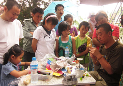 A curious crowd watches a vendor create clay doll at Longtan Park on June 6, 2011. [Photo: CRIENGLISH.com]