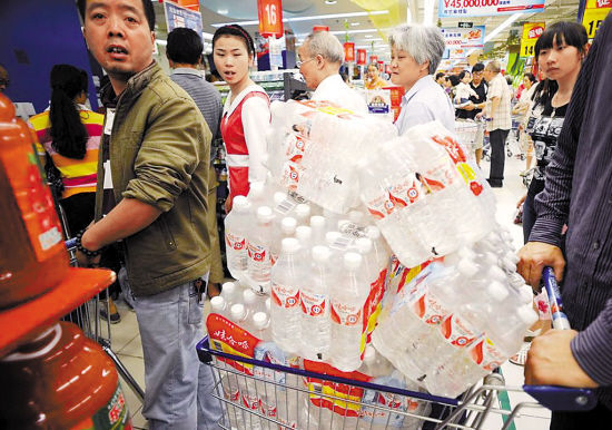 People rush to buy mineral water in a super market of Hangzhou, Zhejiang Province, on July 6 after a chemical spillage threatened the city's water supply. 
