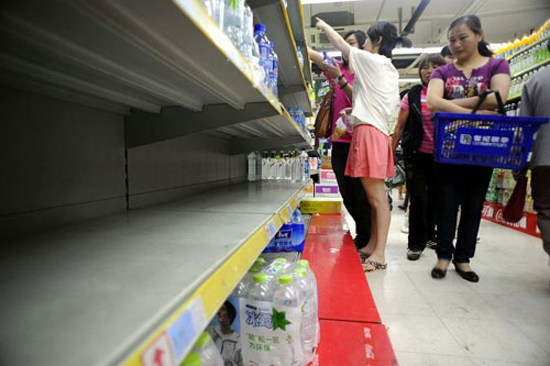People rush to buy mineral water in a super market of Hangzhou, Zhejiang Province, on July 6 after a chemical spillage threatened the city's water supply.