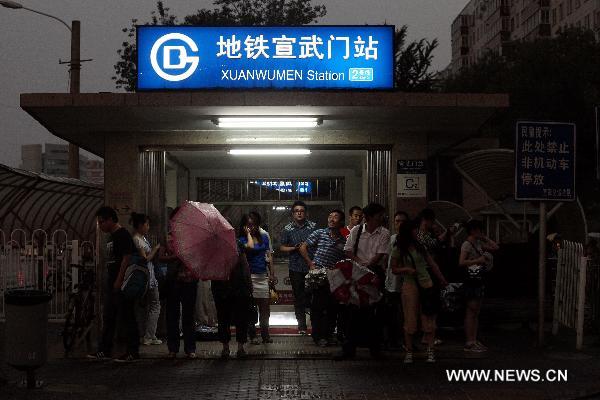 People take shelter from a thunderstorm that poured in Beijing, capital of China, June 7, 2011.