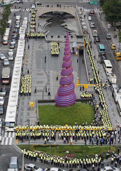 Police buses and police officers surround the Cheonggye stream plaza in central Seoul, June 7, 2011, where university students are planning to hold a rally demanding tuition fees cuts. [China Daily/Agencies]