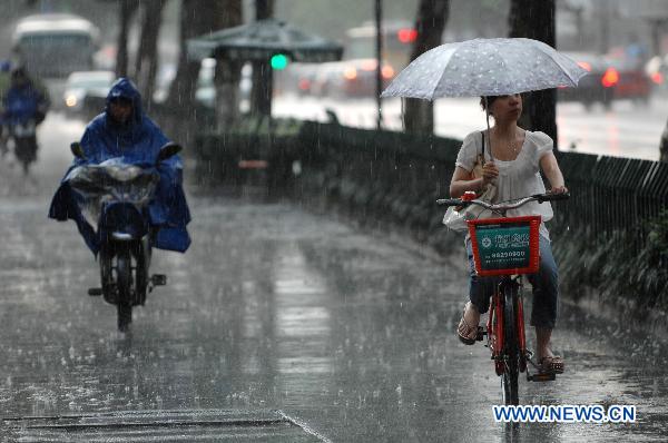 Cyclists move in the rain on a street in Hangzhou, capital of east China&apos;s Zhejiang Province, June 9, 2011. Multiple places in Zhejiang witnessed rainfall on Thursday, which marks the beginning of Meiyu season. Meiyu season is a month-long period in which rain falls continuously for most time. [Xinhua]