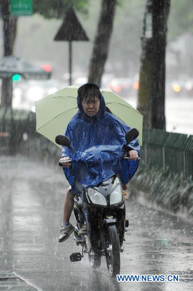 A cyclist moves in the rain on a street in Hangzhou, capital of east China&apos;s Zhejiang Province, June 9, 2011. Multiple places in Zhejiang witnessed rainfall on Thursday, which marks the beginning of Meiyu season. Meiyu season is a month-long period in which rain falls continuously for most time. [Xinhua]