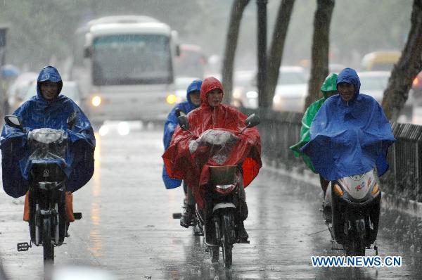 Cyclists move in the rain on a street in Hangzhou, capital of east China&apos;s Zhejiang Province, June 9, 2011. Multiple places in Zhejiang witnessed rainfall on Thursday, which marks the beginning of Meiyu season. Meiyu season is a month-long period in which rain falls continuously for most time. [Xinhua]