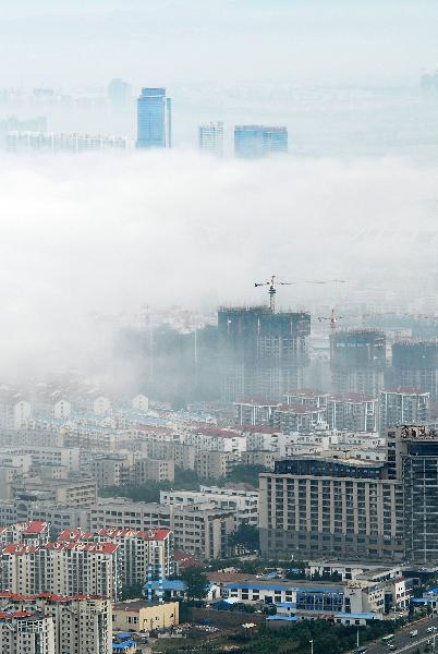 Photo taken on June 9, 2011 shows buildings hovered by silk-like advection fog in Yantai, east China&apos;s Shandong Province. [Xinhua]