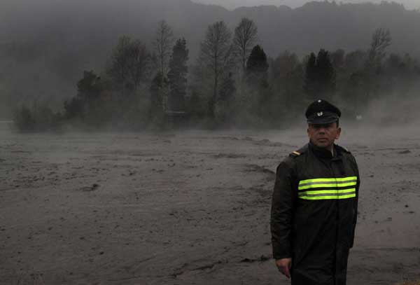 Steam rises from the Nilhue River, fed by unusually warm water from the hot flanks of an erupting volcano from the Puyehue-Cordon Caulle volcanic chain, as a policeman stands on the river bank near Lago Ranco town June 9, 2011. [China Daily/Agencies]