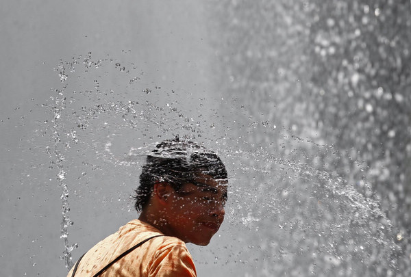 Victor Bennedsen shakes water off his hair after dunking his head in the water fountain at the Hirshhorn Museum and Sculpture Garden in Washington June 9, 2011. Temperatures in the area are expected to exceed 100 degrees Fahrenheit (38 degrees Celsius). [China Daily/Agencies]