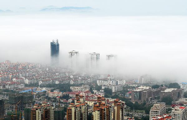 Photo taken on June 9, 2011 shows buildings hovered by silk-like advection fog in Yantai, east China's Shandong Province. [Xinhua/Chu Yang] 
