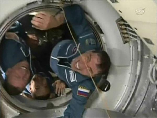 Expedition 28 Flight Engineers (L-R) Mike Fossum, Sergei Volkov and Japan Aerospace Agency astronaut Satoshi Furukawa emerge from the hatch of their Soyuz spacecraft after the hatches opened to the International Space Station in this image from NASA TV June 9, 2011. [Xinhua]