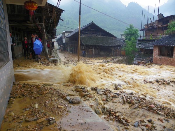 Flood water rushes through a village in Xinhua county, Loudi city of Hunan province, June 5, 2011. [CFP] 