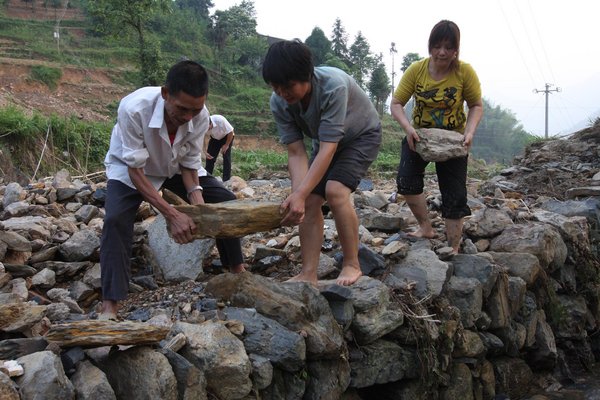 Residents reinforce a riverbank damaged by the flood in Xinhua county, Loudi city of Hunan province, June 8, 2011. [Photo/CFP] 