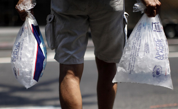 A man carries bags of melting ice down a sidewalk in New York City June 9, 2011. Temperatures soared in New York on Thursday as a heat wave gripped the northeast US. 