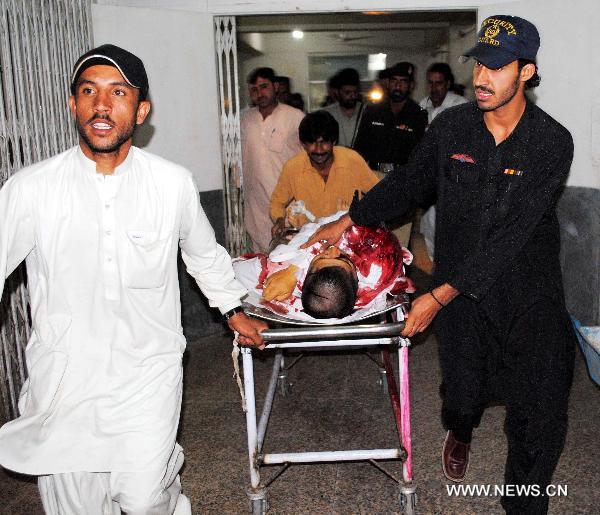 People transfer an injured person to a hospital in Peshawar, northwest Pakistan, June 12, 2011. [Saeed Ahmad/Xinhua]