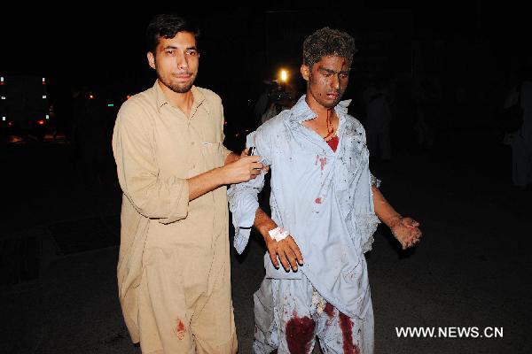 A man helps an injured blast victim in Peshawar, northwest Pakistan, June 12, 2011. [Umar Qayyum/Xinhua]