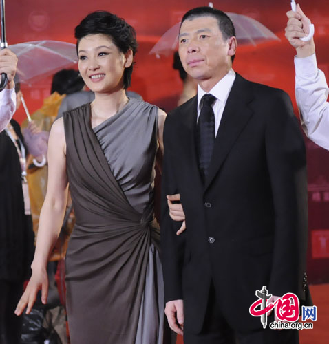 Chinese director Feng Xiaogang (right) and wife Xu Fan walk the red carpet at the opening ceremony of the 14th Shanghai International Film Festival at Shanghai Grand Theater on rainy Saturday. [Pang Li/China.org.cn]