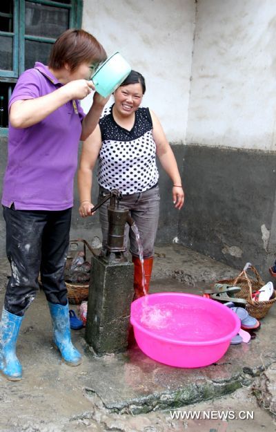 VVillagers get water from a well in Taoshu Village of Xiushui County, east China's Jiangxi Province, June 11, 2011. Rain-triggered flood hit the county on Friday. Flood-relief works have been carried out in Xiushui to reduce the economic losses. [He Guang/Xinhua] 