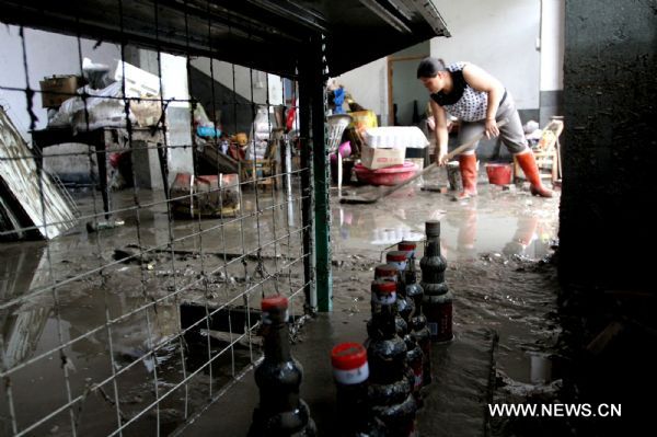 A villager clear silt at home in Taoshu Village of Xiushui County, east China's Jiangxi Province, June 11, 2011. Rain-triggered flood hit the county on Friday. Flood-relief works have been carried out in Xiushui to reduce the economic losses. [He Guang/Xinhua]