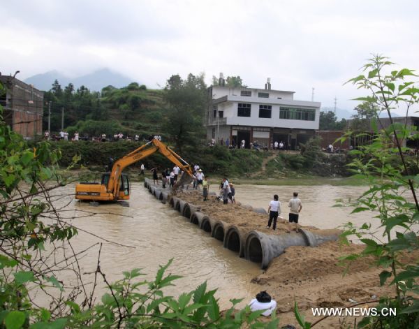 An excavator work to repair a bridge in Huangshaduan Village of Xiushui County, east China's Jiangxi Province, June 11, 2011. Rain-triggered flood hit the county on Friday. Flood-relief works have been carried out in Xiushui to reduce the economic losses. (Xinhua/Huang Yiwei)(mcg) 