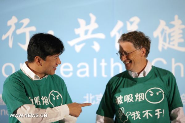 Microsoft chairman and co-chair of the Bill and Melinda Gates Foundation (BMGF) Bill Gates (R) smiles after he and Robin Li, founder and chief executive of Chinese search engine Baidu, put on shirts bearing the slogan 'Say No to Involuntary Smoking' at a press conference in Beijing, capital of China, June 11, 2011. Gates and Li signed an agreement to form a charitable alliance in a joint effort to promote a smoking-free society in China. [Cui Xinyu/Xinhua] 