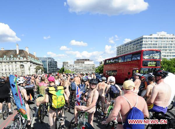 Naked cyclists gather on the Westminster Bridge in central London, Britain, June 11, 2011. Hundreds of naked bike riders took part in the eighth annual London World Naked Bike Ride by cycling across central London, appealing for cyclist rights on roads and reducing the global dependency on oil.[Zeng Yi/Xinhua]