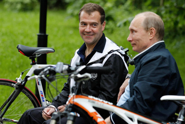 Russian President Dmitry Medvedev (L) and Prime Minister Vladimir Putin chat after riding their bicycles during an informal meeting at the presidential residence at Gorki, outside Moscow June 11, 2011. [Photo/Agencies]