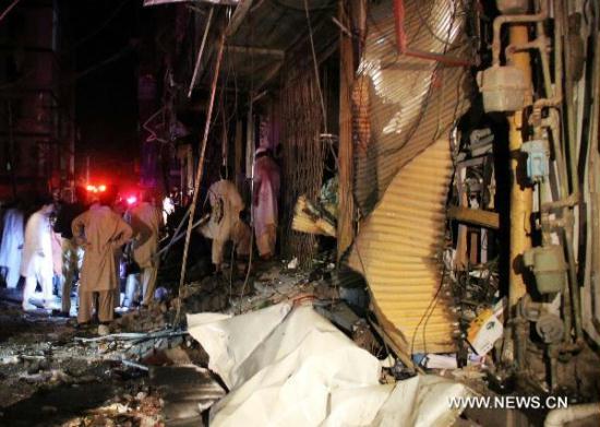 People gather at the blast site in Peshawar, northwest Pakistan, June 11, 2011. 