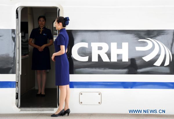 A train attendent stands next to a high speed train in Shanghai, east China, June 12, 2011. Attendants started working on trains so as to get used to the new line which provides a four-hour link between Beijing and Shanghai once fully in operation late 2011. [Xinhua]