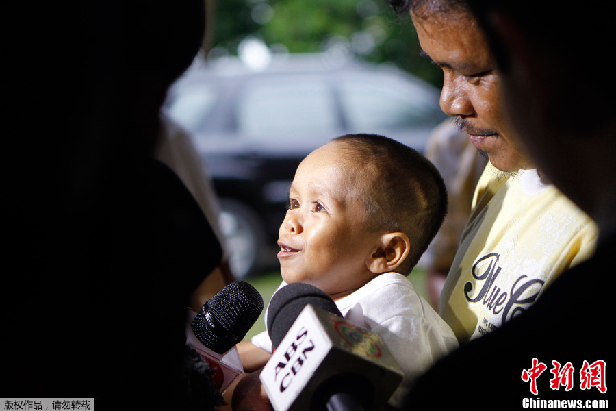 Junrey Balawing, carried by his father, talks to reporters in Sindangan, Zamboanga del Norte in southern Philippines June 11, 2011. [Photo/Chinanews.com.cn]