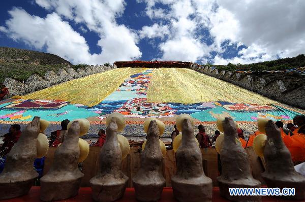 Photo taken on June 12, 2011 shows the Buddha Tangka painting unfolding ceremony in Curpu Temple, 70 kilometers away from Lhasa, capital of southwest China&apos;s Tibet Autonomous Region. The annual Buddha Tangka painting unfolding ceremony was held in Curpu Temple on Sunday. [Xinhua] 